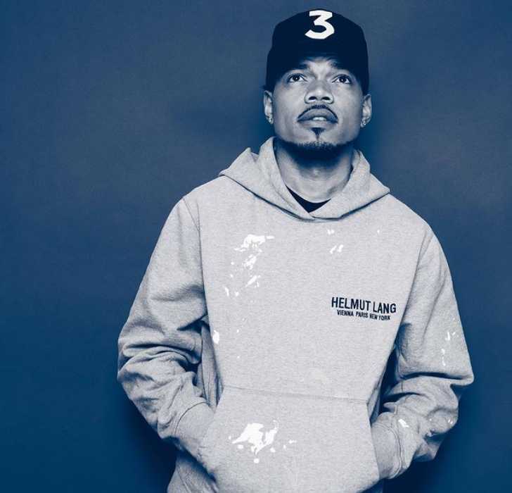 Picture of Chance The Rapper posing for a photo keeping both hands in pocket and with cap on.